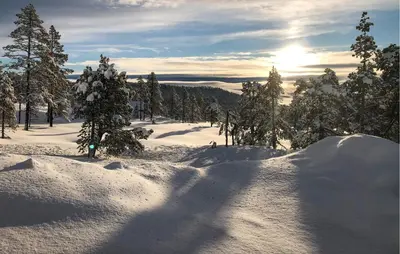 a snow covered slope with trees and the sun in the distance at Beautiful Home In Flå With Kitchen in Flå
