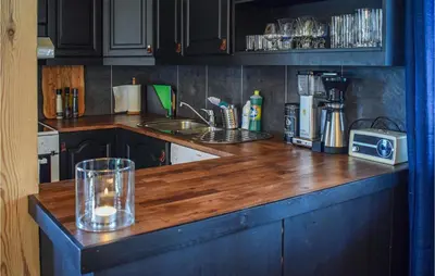 a kitchen with a wooden counter top with a candle on it at Cozy Home In Hovden I Setesdal in Hovden
