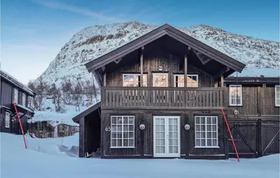 a log cabin in the snow with a mountain at Beautiful Home In Hovden I Setesdal in Hovden