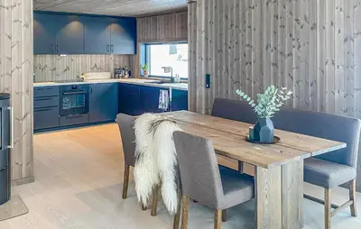 a kitchen with a wooden table and blue cabinets at Awesome Home In Hønefoss With Wifi in Hønefoss
