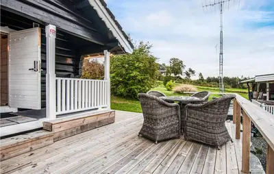 a porch with wicker chairs on a wooden deck at Stunning Home In Frosta