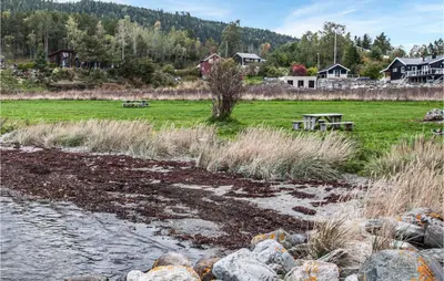 a picnic table in a field next to a river at Stunning Home In Frosta