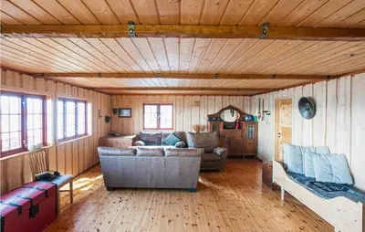 a living room with a couch and wooden walls at Nice Home In Malm With Lake View in Malm