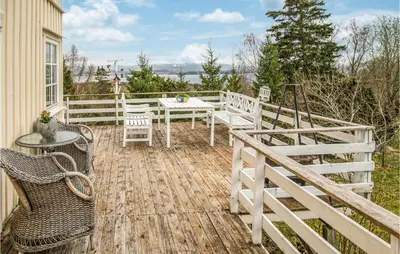 a wooden deck with a table and chairs on a house at Amazing Home In Ytterøy With Wifi