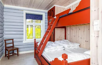 a bedroom with an orange bunk bed and a chair at Nice Home In Hemsedal With Sauna in Hemsedal