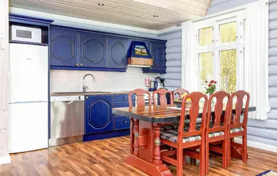 a kitchen with blue cabinets and a wooden table and chairs at Nice Home In Hemsedal With Sauna in Hemsedal