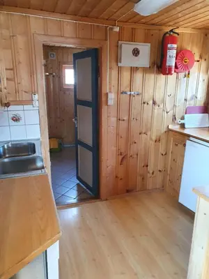 a kitchen with wooden walls and a door in a room at Bjørklund in Geilo