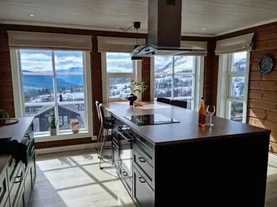 a kitchen with a large island with a counter top at Fosskamben Panorama Sogndal in Sogndal