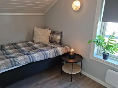 a small bedroom with a bed and a table at Fosskamben Panorama Sogndal in Sogndal