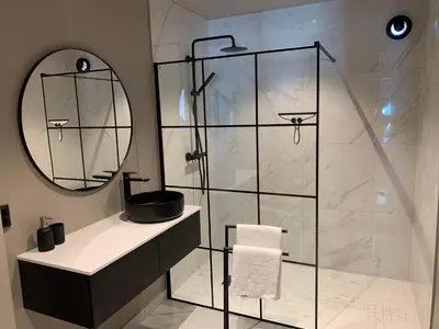 a bathroom with a shower with a sink and a mirror at Trolltunga Panorama in Tysso