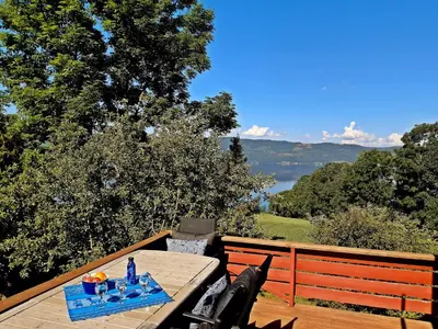 a table on a deck with a view of a lake at Randsfjord house in Gran