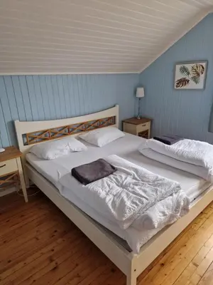 a bedroom with a large bed with white sheets at Randsfjord house in Gran