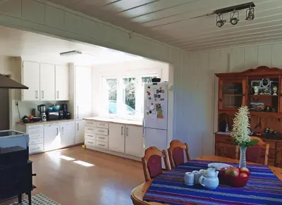 a kitchen with a table and a white refrigerator at Randsfjord house in Gran