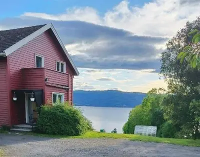 a red house with a view of a lake at Randsfjord house in Gran
