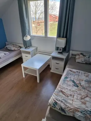 a room with two beds and a table and a window at Randsfjord house in Gran