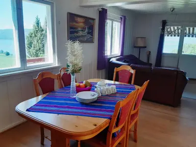 a dining room table with a blue striped table cloth at Randsfjord house in Gran