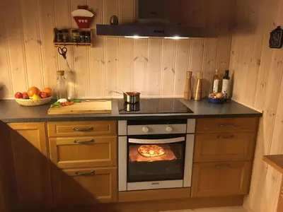 a kitchen with a pizza cooking in an oven at Reinunga Eco Hytta - Mountain lodge near Myrdal accessible only by train or bike in Myrdal