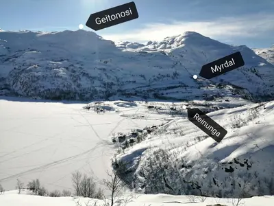 two street signs in the snow on a mountain at Reinunga Eco Hytta - Mountain lodge near Myrdal accessible only by train or bike in Myrdal