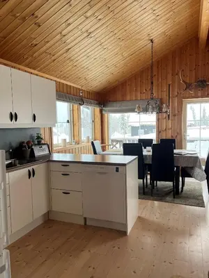 a kitchen and dining room with a table and chairs at Koselig hytte - Trysilfjellet ski in og ski out 4 soverom, 2 bad, badstue, fiber bredbånd og Elbillader in Trysil