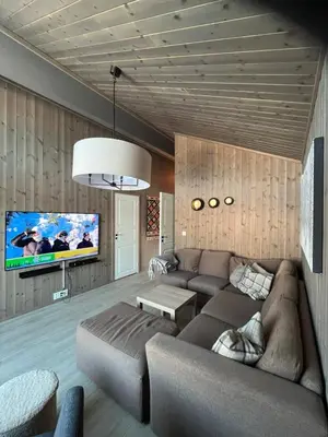 a living room with a couch and a flat screen tv at Koselig hytte - Trysilfjellet ski in og ski out 4 soverom, 2 bad, badstue, fiber bredbånd og Elbillader in Trysil