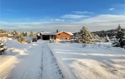 a snow covered road leading to a house at Amazing Home In Tisleidalen With Sauna in Hovda