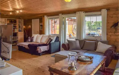 a living room with a couch and a table at Amazing Home In Tisleidalen With Sauna in Hovda
