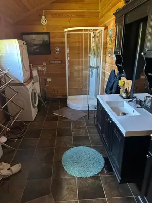 a bathroom with a shower and a sink and a tub at Trollvang, hytte med pool og sauna in Dovreskogen