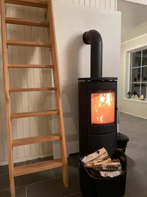 a stove in a room with a wooden ladder at Hytte i nydelige Jotunhemen - rett ved Besseggen in Randsverk