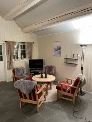 a living room with a table and chairs and a tv at Hytte i nydelige Jotunhemen - rett ved Besseggen in Randsverk