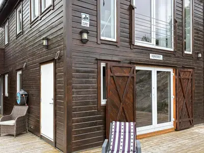 a wooden house with a wooden door and windows at 6 person holiday home in Urangsvåg-By Traum in Ervik