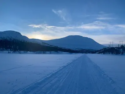 a snow covered road with mountains in the distance at Tveitopark Apartments A in Rjukan