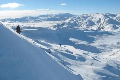 two people are skiing down a snow covered mountain at Snøya Lodge in Hemsedal