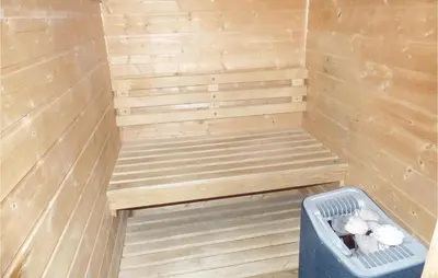 a wooden sauna with a bench and a trash can at Bergheim in Vikersund