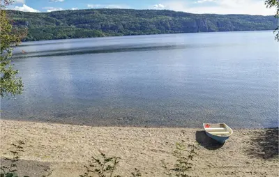 a small boat sitting on the shore of a lake at Solbakken in Vikersund