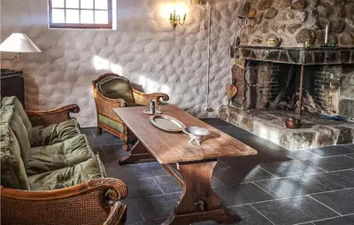 a living room with a table and a fireplace at Amazing Home In Åmotsdal With Kitchen in Åmotsdal