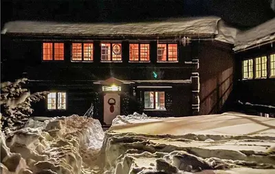 a house is covered in snow at night at Amazing Home In Åmotsdal With Kitchen in Åmotsdal
