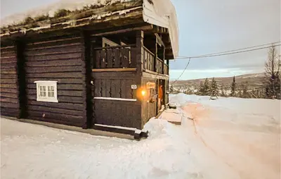 a log cabin in the snow with a light at Nice Home In Vinstra With Kitchen in Vinstra