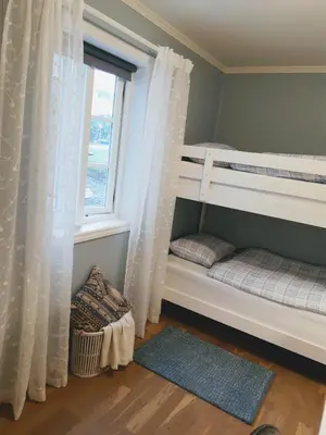a bedroom with two bunk beds and a window at Trygheim feriehus in Bud