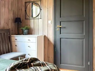 a bedroom with a door and a dresser and a mirror at 10 person holiday home in veggli-By Traum in Veggli
