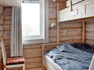 a bedroom with wooden walls and a bed and a window at 8 person holiday home in HURDAL-By Traum in Hurdal