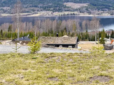 a house on a hill next to a lake at 8 person holiday home in HURDAL-By Traum in Hurdal