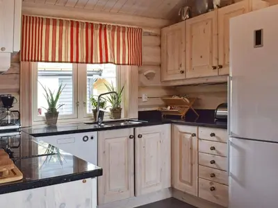 a kitchen with wooden cabinets and a white refrigerator at 8 person holiday home in HURDAL-By Traum in Hurdal