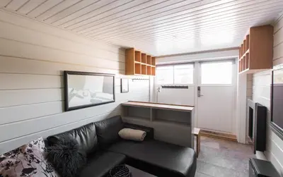 a living room with a couch and a tv at Mosetertoppen Panorama anneks 1B in Hafjell