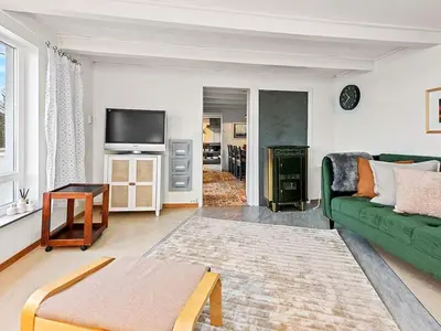a living room with a green couch and a tv at 6 person holiday home in MIDSUND-By Traum in Aukra