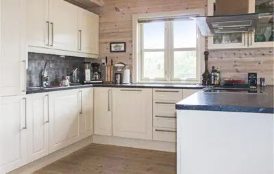 a kitchen with white cabinets and a sink and a window at 4 Bedroom Nice Home In Sogndal in Sogndal