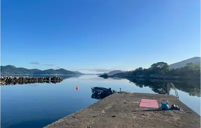 a dock on a body of water with mountains in the background at 3 Bedroom Amazing Home In Skjold in Skjold