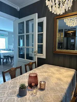 a dining room with a table and a mirror at VILLA HASSELBAKKEN in Eidsvoll