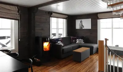 a living room with a couch and a fireplace at Hafjell tømmerhytte 4B in Hafjell