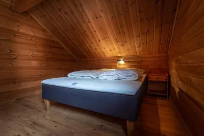 a bedroom with a bed in a wooden cabin at Beito Resort Hytter in Beitostøl