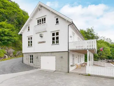 a white house with a dog sitting on a driveway at 8 person holiday home in Ørskog-By Traum in Ørskog